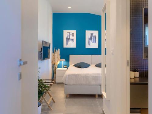 a bedroom with a bed with a blue wall at Apartment Penthouse Mira by Interhome in Umag