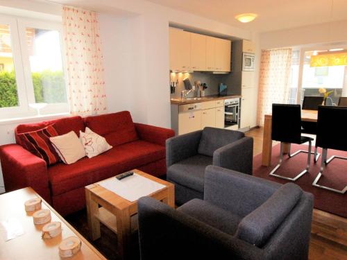 ein Wohnzimmer mit einem Sofa, Stühlen und einem Tisch in der Unterkunft Apartment Tom & Jeri by Interhome in Kaprun