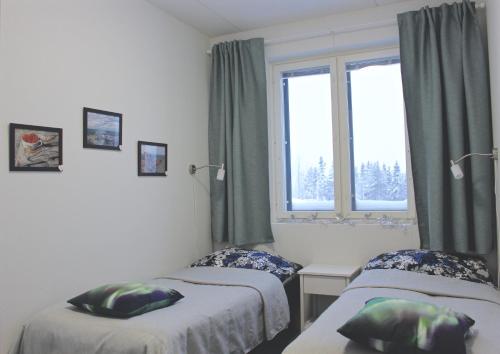 um quarto com duas camas e uma janela em Lapland Happiness Skistar 201 em Äkäslompolo