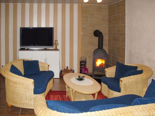 a living room with two chairs and a fireplace at Holiday Home Siglinde by Interhome in Goldberg