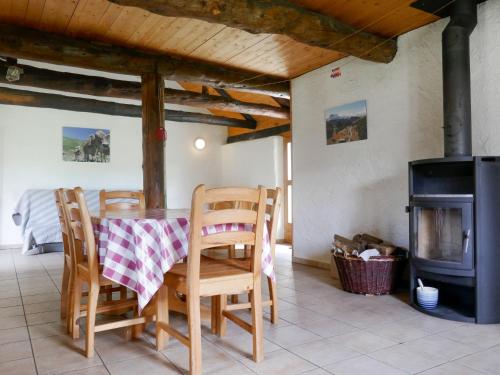 a dining room with a table and chairs and a stove at Holiday Home Rustico Dolomia by Interhome in Acquacalda