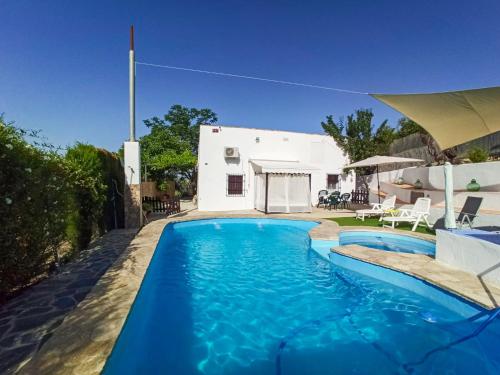 a swimming pool in front of a house at Holiday Home El Viso by Interhome in Zambra