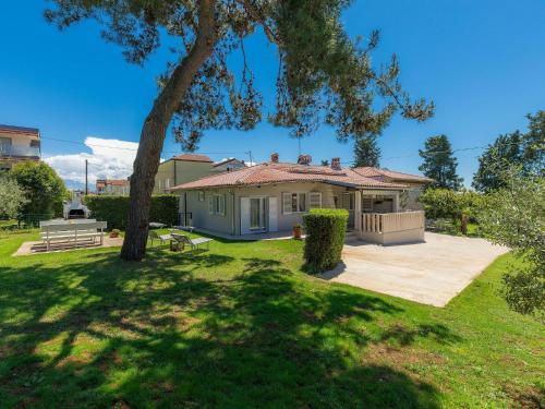 a house in a yard with a tree at Holiday Home Punta 2 by Interhome in Umag
