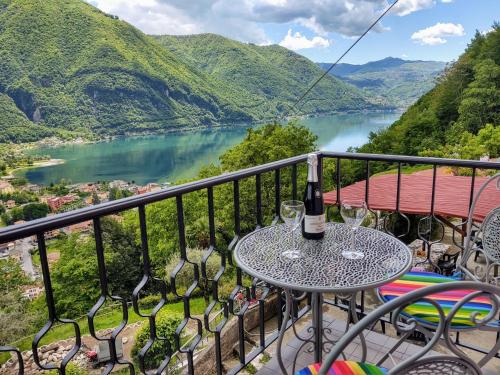a table with a bottle of wine on a balcony overlooking a river at Holiday Home Casa Pina by Interhome in Porlezza