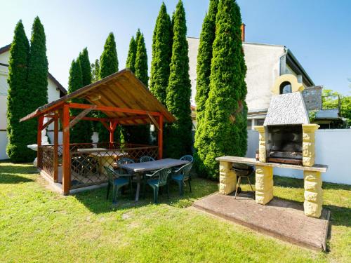 a backyard with a picnic table and a grill at Villa Big Thuja by Interhome in Balatonföldvár
