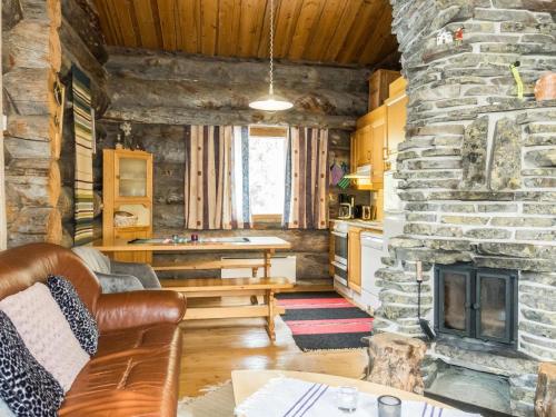 a living room with a stone fireplace in a cabin at Holiday Home Luostonseita 1 by Interhome in Luosto
