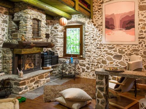 a living room with stone walls and a fireplace at Holiday Home Al Fopp by Interhome in Masino