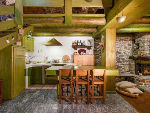 una cucina con soffitti in legno, tavolo e sedie di Holiday Home Al Fopp by Interhome a Masino