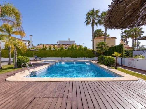 - une piscine avec une terrasse en bois à côté d'une maison dans l'établissement Holiday Home Gran Olamar Golf by Interhome, à Oliva