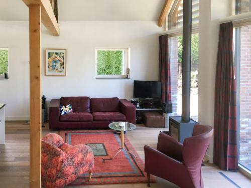 uma sala de estar com um sofá e uma mesa em Holiday Home De Meestoof by Interhome em Kapelle