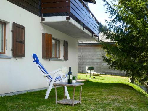 a patio with a table and a chair and a bottle of wine at Apartment Cà Bias by Interhome in Campo Blenio