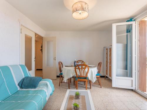 un salon avec un canapé bleu et une table dans l'établissement Apartment Le Solarium by Interhome, à Narbonne-Plage