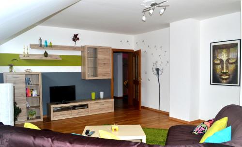 a living room with a couch and a tv at Ferienwohnung Schrittwieser in Faak am See