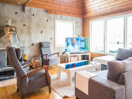a living room with a couch and a tv at Holiday Home Tahkon rantatupa 7 b by Interhome in Tahkovuori