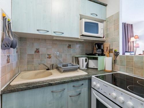 une cuisine avec un évier et un micro-ondes dans l'établissement Apartment Los Amigos-13 by Interhome, au Grau-du-Roi