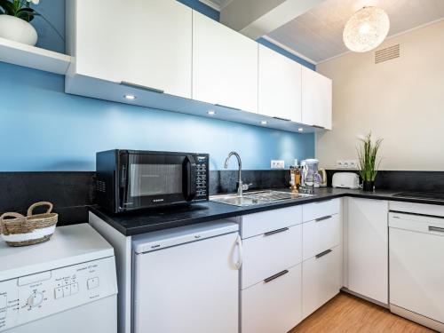 une cuisine avec des armoires blanches et un micro-ondes dans l'établissement Studio Port An Dro-6 by Interhome, à Carnac