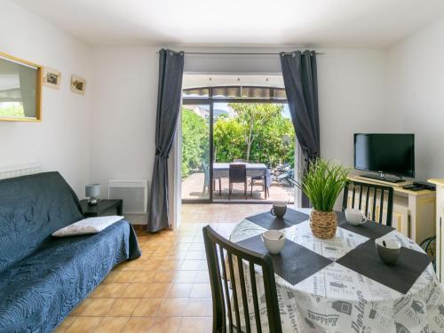 a living room with a table and a couch at Apartment Les Tulipes by Interhome in Carqueiranne