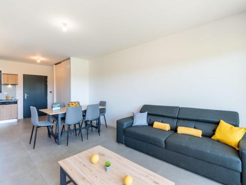 un salon avec un canapé bleu et une table dans l'établissement Apartment Stanatura-3 by Interhome, à Porto-Vecchio