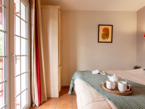 Cette chambre comprend un lit avec une table et une fenêtre. dans l'établissement Apartment Les Terrasses d'Arcangues-4 by Interhome, à Arcangues