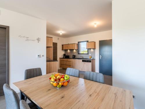 - un bol de fruits sur une table en bois dans la cuisine dans l'établissement Apartment Stanatura-3 by Interhome, à Porto-Vecchio