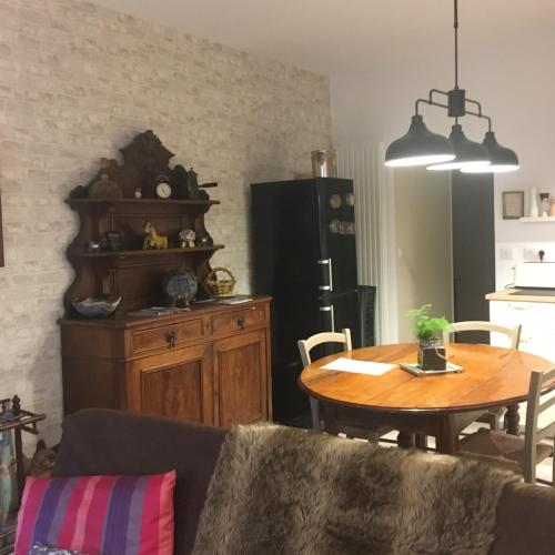 - un salon avec une table et un réfrigérateur noir dans l'établissement Appartement génial, à Clermont-Ferrand
