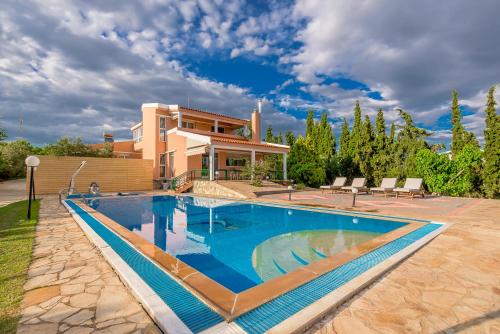 a large swimming pool in front of a house at Villa Konstantinos in Alexandroupoli