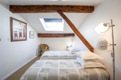 une chambre avec deux lits et un plafond avec poutres dans l'établissement Bordeaux Hyper Centre proche Tourny, à Bordeaux