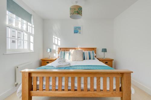 a bedroom with a wooden bed with blue sheets at Juniper House in Harwich