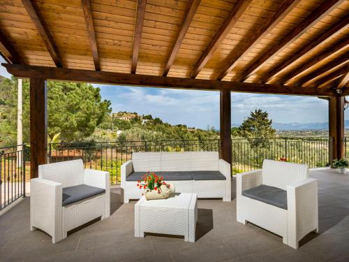 eine Terrasse mit weißen Möbeln und einem Holzdach in der Unterkunft Villa Mari e Monti by Interhome in Castellammare del Golfo