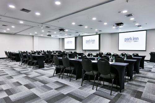 a conference room with tables and chairs and screens at Park Inn by Radisson Berrini in Sao Paulo