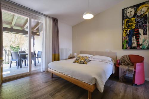 a bedroom with a large bed and a dining room at Villaggio Turistico Lugana Marina in Sirmione