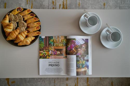 a magazine and a plate of bread and a cup of coffee at Five Seasons Szklarska Poręba in Szklarska Poręba