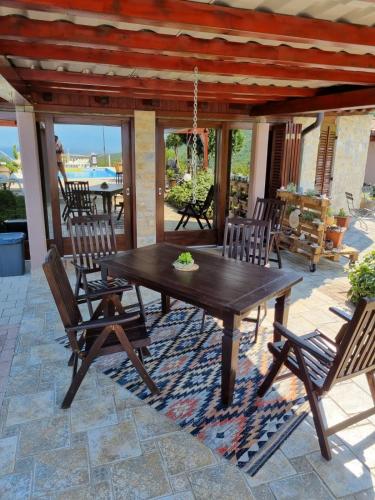 a wooden table and chairs on a patio at Casa Perla Holidays in Juraši