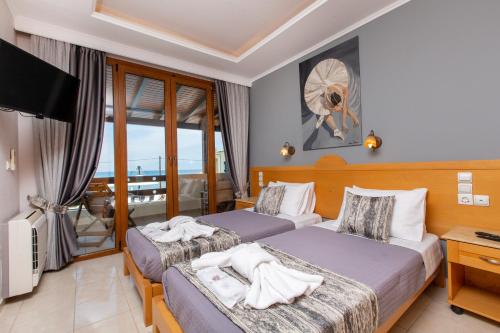 a hotel room with two beds and a television at Medusa's Villas in Acharavi