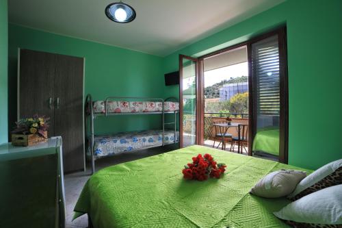 ein grünes Schlafzimmer mit einem Bett mit Blumen darauf in der Unterkunft B&B PRINCESS ROOM in Capo dʼOrlando