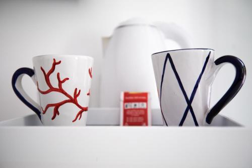 two coffee mugs sitting on a shelf at Positamy in Positano