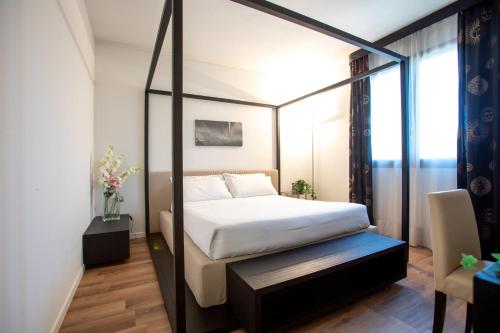 ein Schlafzimmer mit einem Himmelbett in einem Zimmer in der Unterkunft Matrix Hotel & Residence in Vigonza