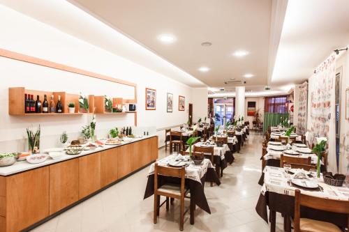 un restaurante con mesas y sillas en una habitación en Hotel Gaia, en Rímini