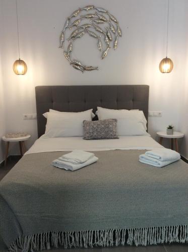 a bedroom with a large bed with two towels on it at studios FLORA in naoussa paros in Naousa