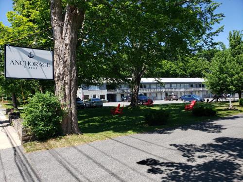 a sign on a tree next to a building at Anchorage Motel in Bar Harbor