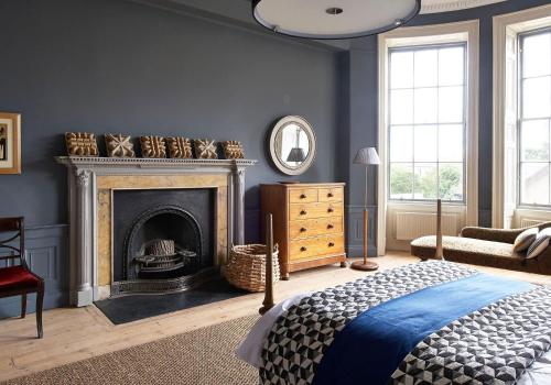 愛丁堡的住宿－The Art House at The New Town，一间蓝色的卧室,配有壁炉和一张床