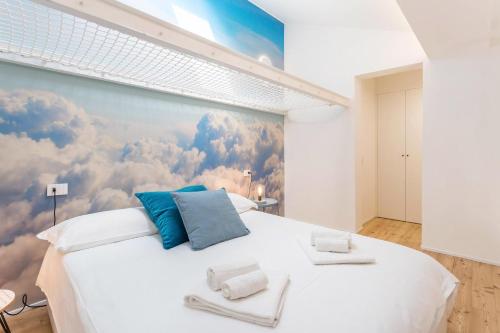 sypialnia z dużym białym łóżkiem z chmurami malowanymi na ścianie w obiekcie Bellagio amorevole dimora in Lecco w mieście Lecco