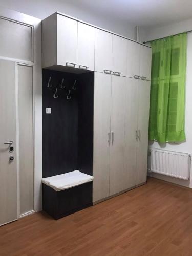 a room with white cabinets and a bench in it at ATA Apartment in Skopje