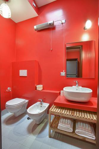 a red bathroom with a toilet and a sink at B&B Al Colle in Pescosolido