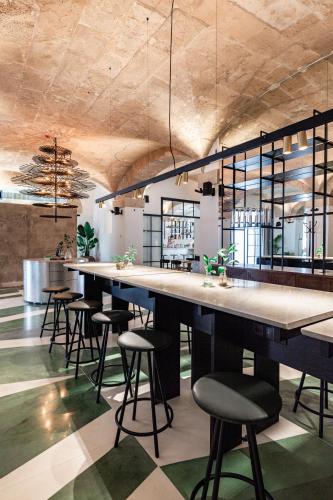 a bar with a row of stools in a room at Concepcio by Nobis, Palma, a Member of Design Hotels in Palma de Mallorca