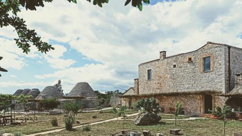 an old stone building with domes in the background at Masseria LoJazzo in Ceglie Messapica