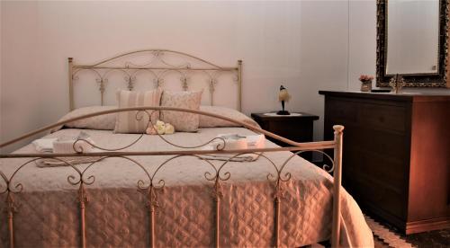 een slaapkamer met een metalen bed, een dressoir en een spiegel bij La Rosa Antica in Avetrana