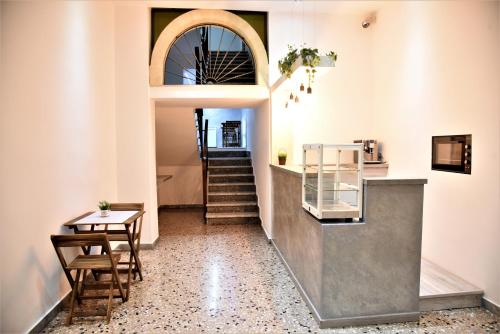 un corridoio con tavolo e scale in un edificio di La Rosa Antica ad Avetrana