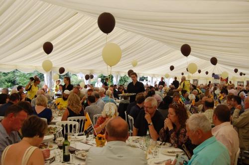a large group of people sitting at tables in a tent at The Grove Cromer in Cromer