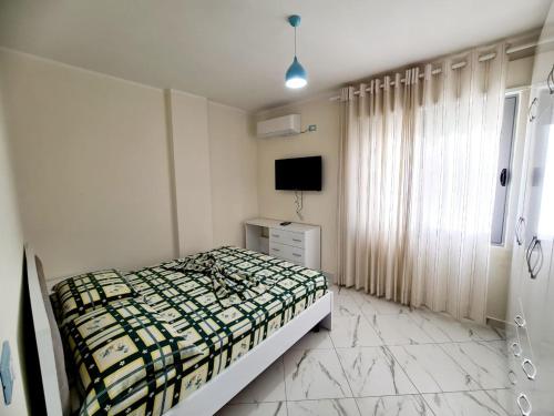 a bedroom with a bed and a television in it at Sky - Apartment - Brown in Vlorë